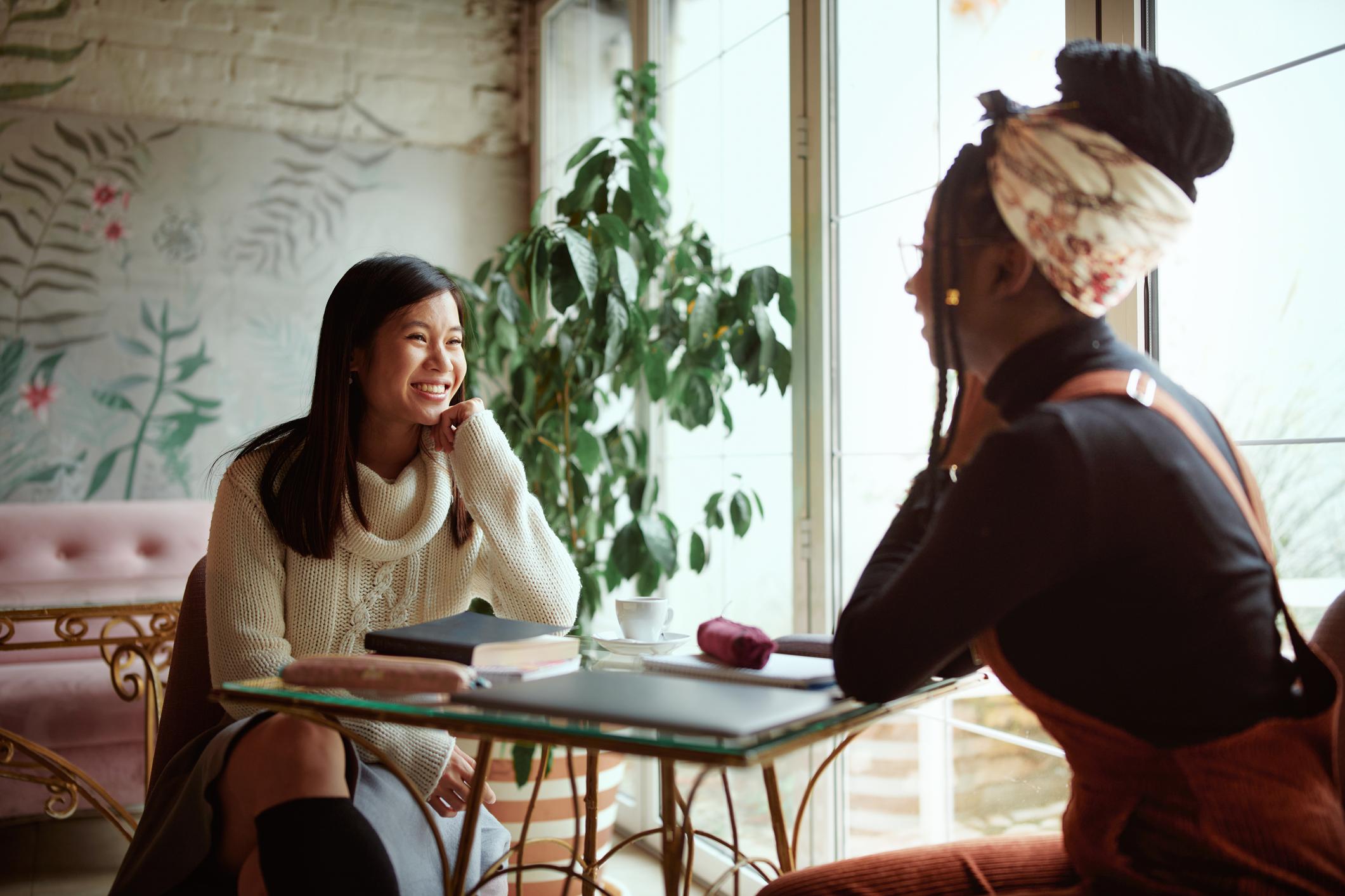 two female students chatting at table